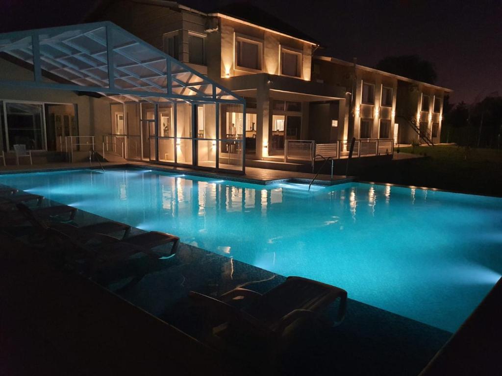 una grande piscina di fronte a una casa di notte di StradivariuS Hotel Boutique a Villa General Belgrano