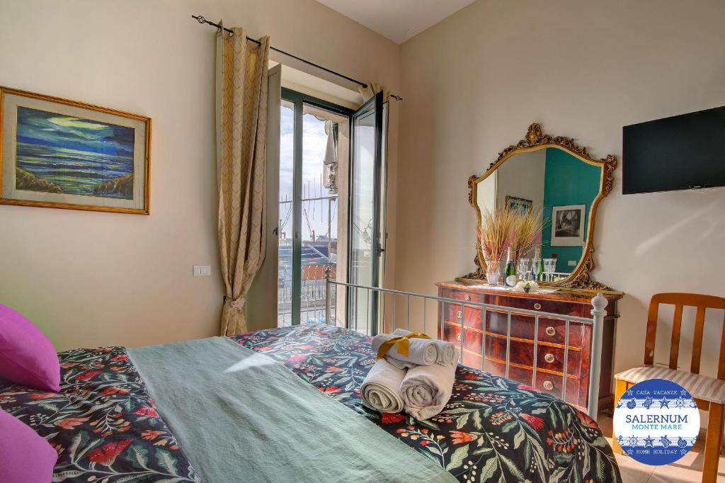 een slaapkamer met een bed, een spiegel en een dressoir bij SALERNUM - MONTE MARE in Salerno