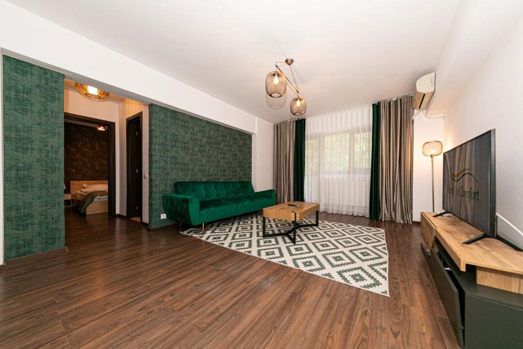 un salon avec un canapé vert et une télévision dans l'établissement One Bedroom near Floreasca Park, à Bucarest
