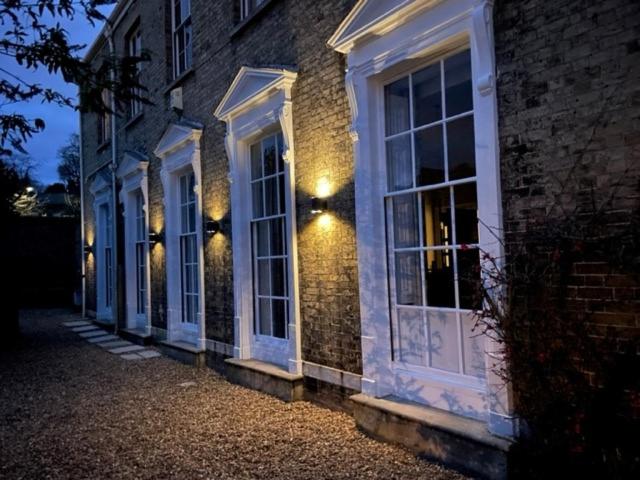 a brick building with white windows and lights on it at Unique Georgian Splendour at The Old Ballroom sleeps 2 with sofabed 4 add The Studio at extra cost to sleep 2 more in Norwich