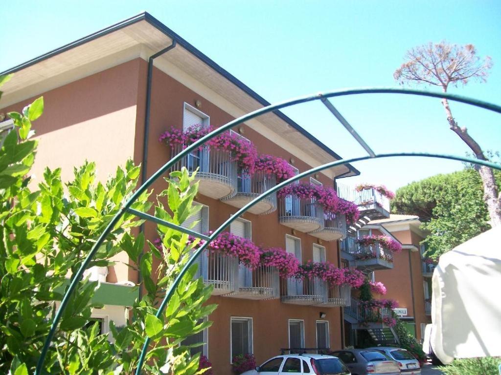 a building with purple flowers on the balconies at Hotel Nazionale in Milano Marittima