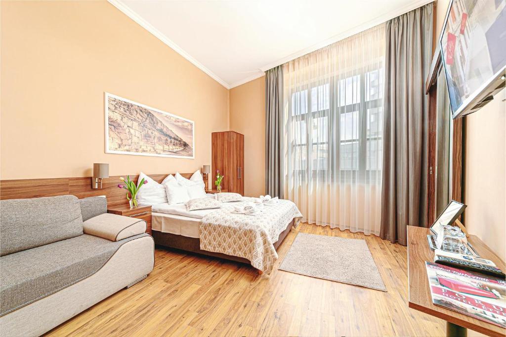 une chambre d'hôtel avec un lit et un canapé dans l'établissement Forum Hotel, à Szombathely