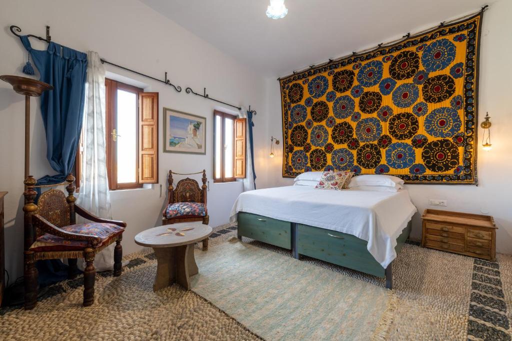 a bedroom with a bed and a table and a chair at Villa Venetoklis in Líndos