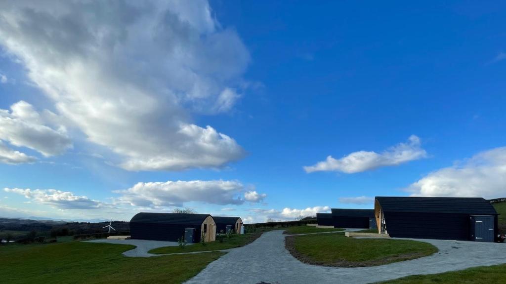 una carretera que conduce a dos edificios en un campo en Hedgehog's Nest en Bathgate