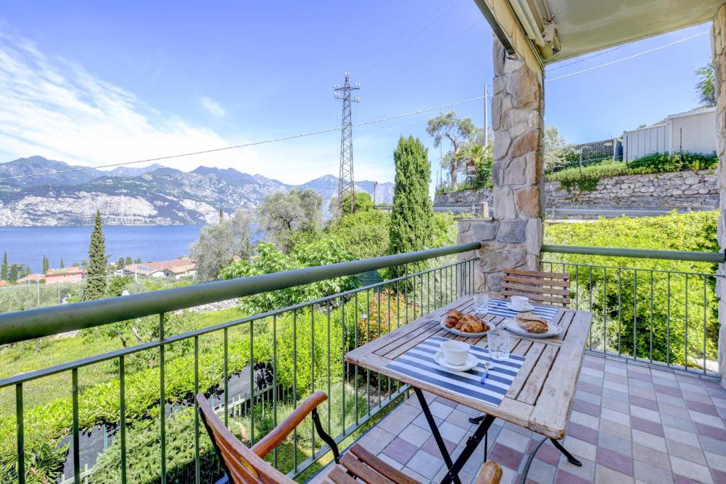 una mesa en un balcón con vistas al agua en Malcesine Dream Apartments, en Malcesine