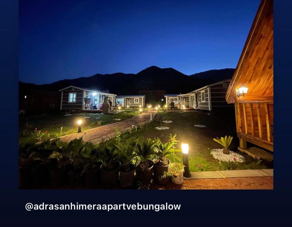 a view of a yard at night with lights at ADRASAN HİMERA APART & BUNGALOW in Adrasan
