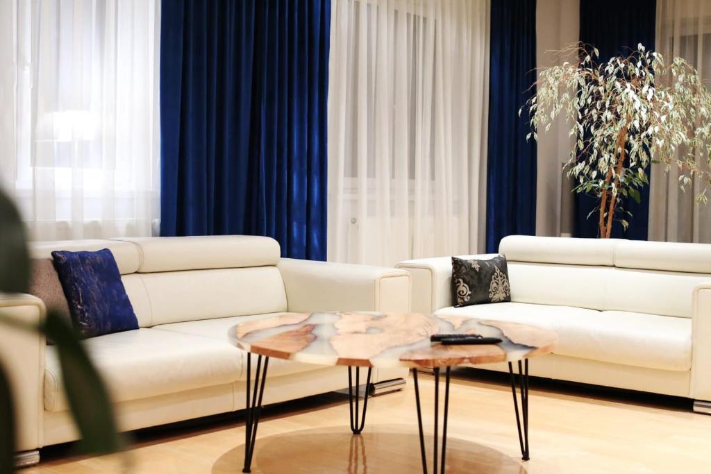 uma sala de estar com dois sofás brancos e uma mesa em Villa pod Szczeblem em Kasinka