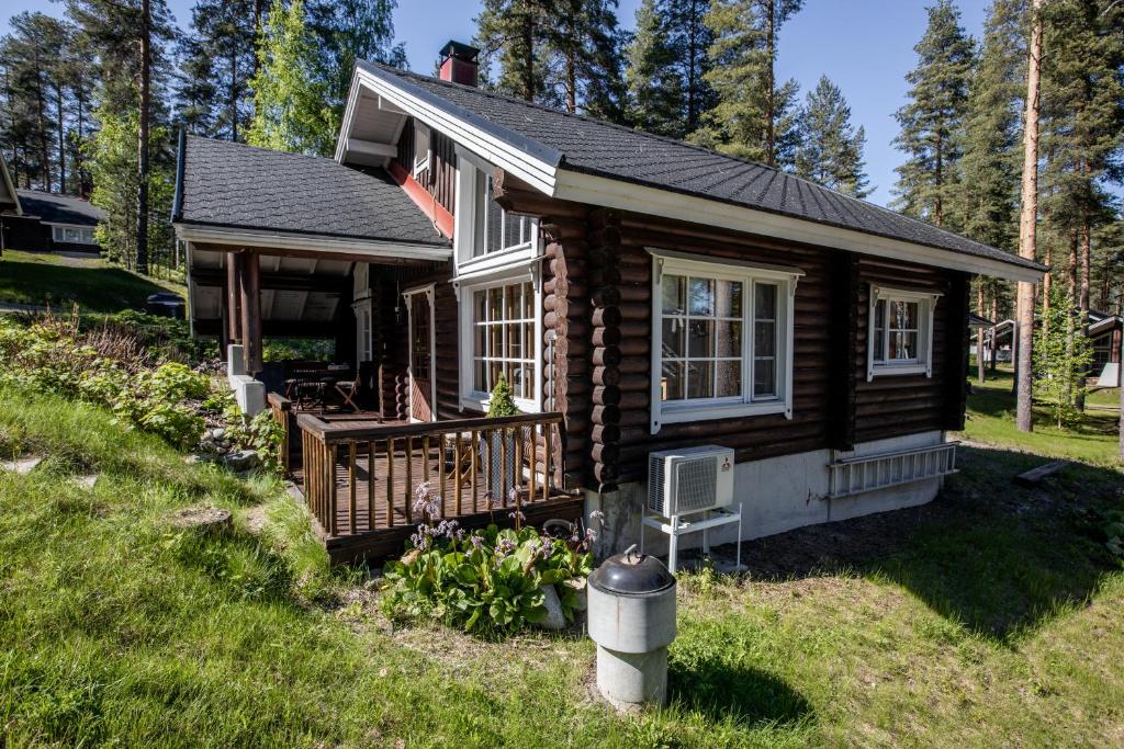 a small log cabin with a porch and a yard at Kolin Vernetti 3 in Kolinkylä
