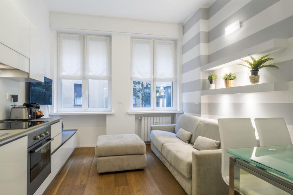 un soggiorno con divano e tavolo di Easylife - San Babila - Elegante e rifinito bilocale nel cuore della città a Milano