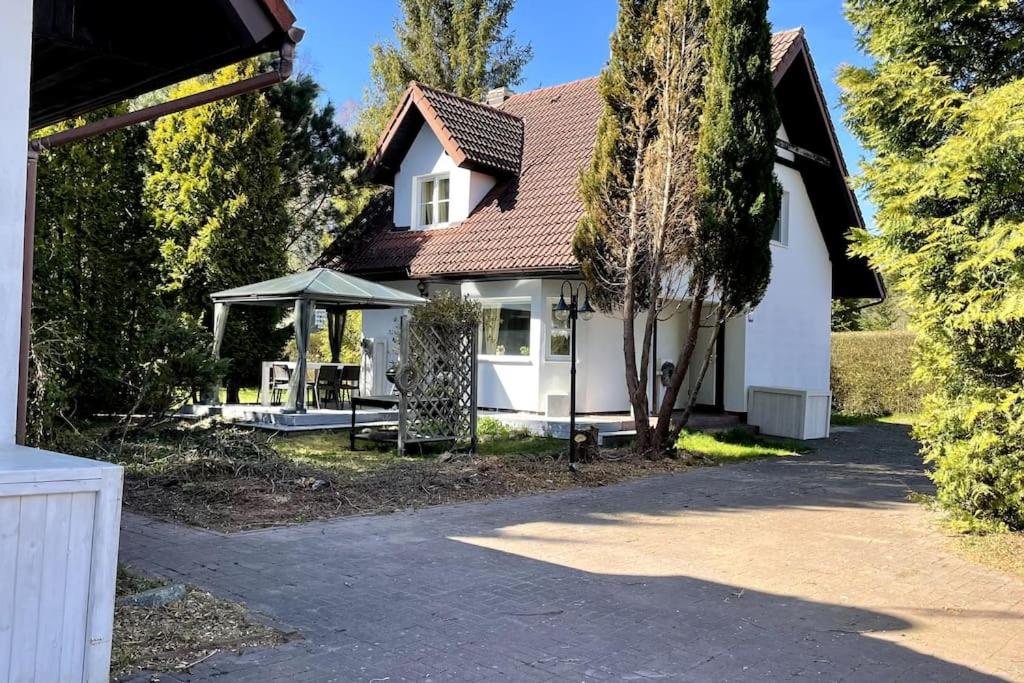 a white house with a gazebo at Uroczy domek nad samym morzem in Dębki