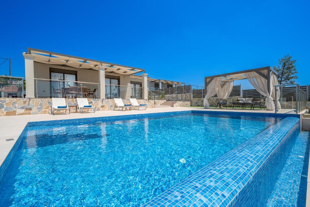 uma piscina numa villa com água azul em Marianna Villas - Aria - em Argostólion