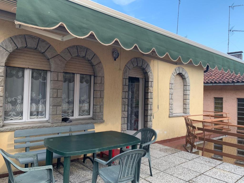 une table et des chaises vertes à l'extérieur d'un bâtiment dans l'établissement Casa Vacanza da Violetta, à Faedis