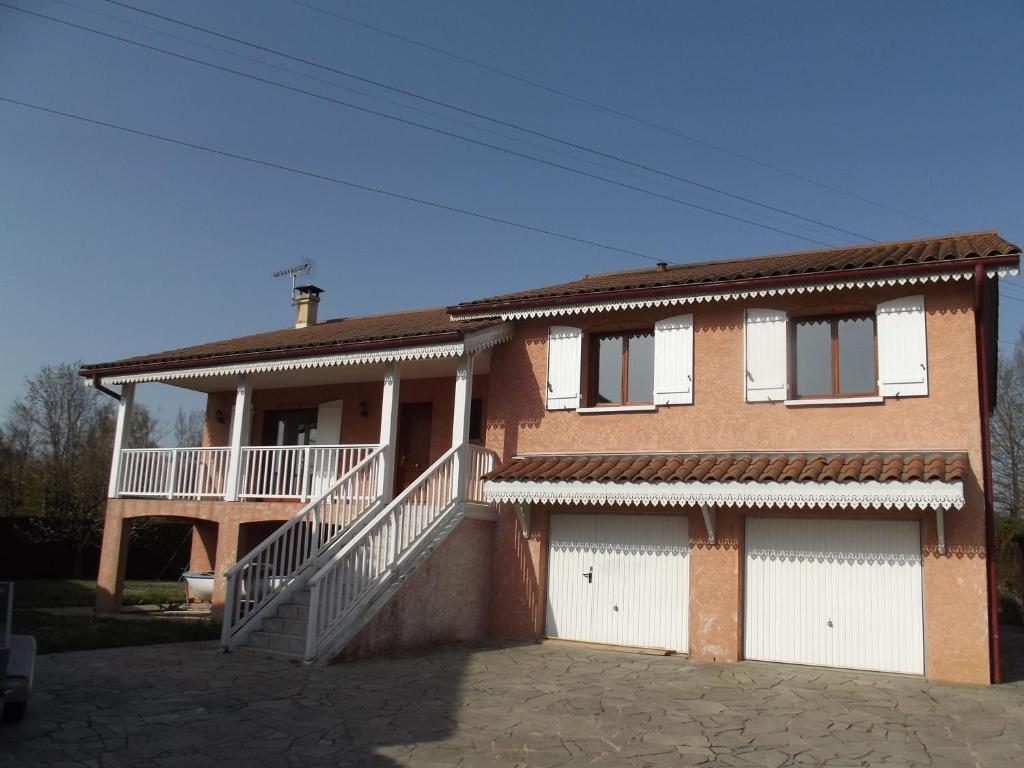 a house with white doors and a balcony at Grand Appartement avec cheminée dans maison, parking gratuit in Mionnay