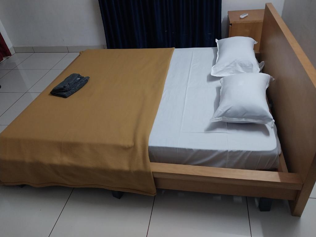 a bed with a wooden frame and two pillows on it at lloydskochi home stay in Cochin