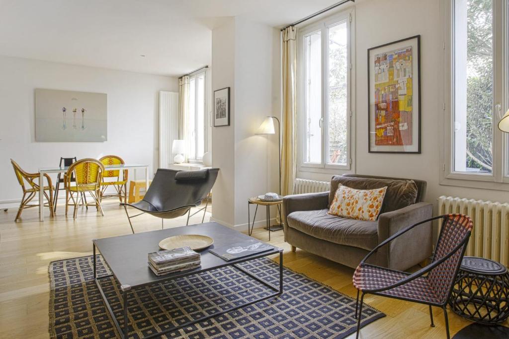 uma sala de estar com um sofá e uma mesa em Maison de l'Ermitage - Welkeys em Le Bouscat