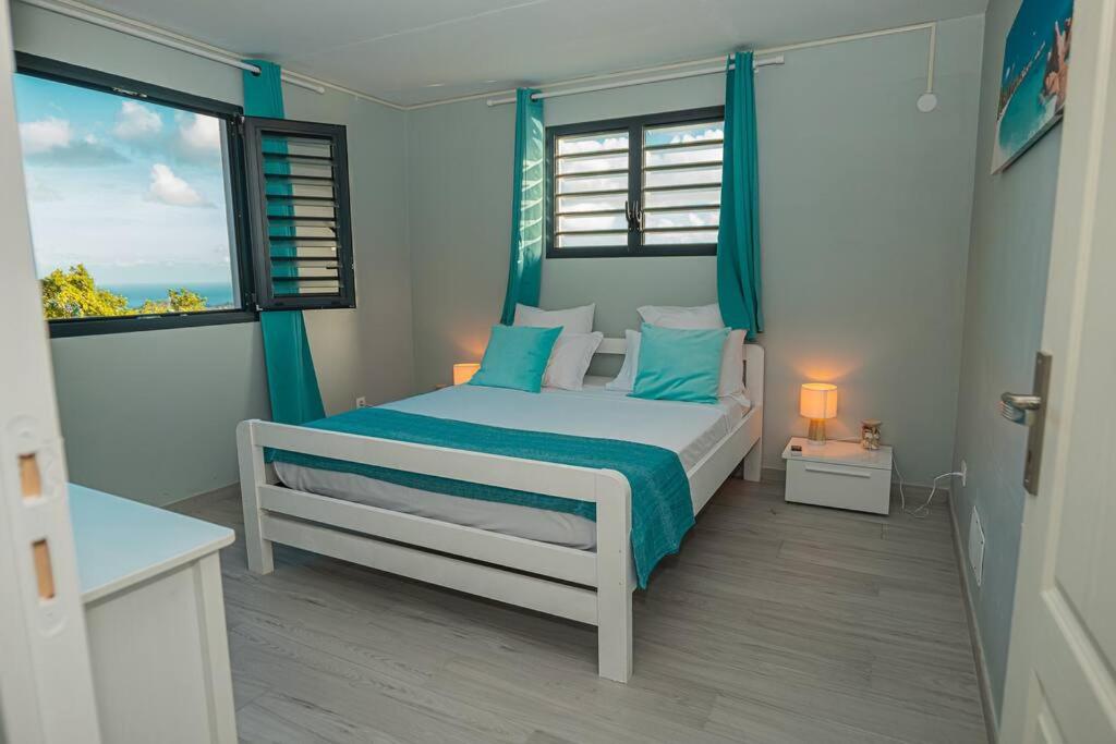 Rivière-PiloteにあるVT cottageのベッドルーム1室(青い枕のベッド1台、窓付)