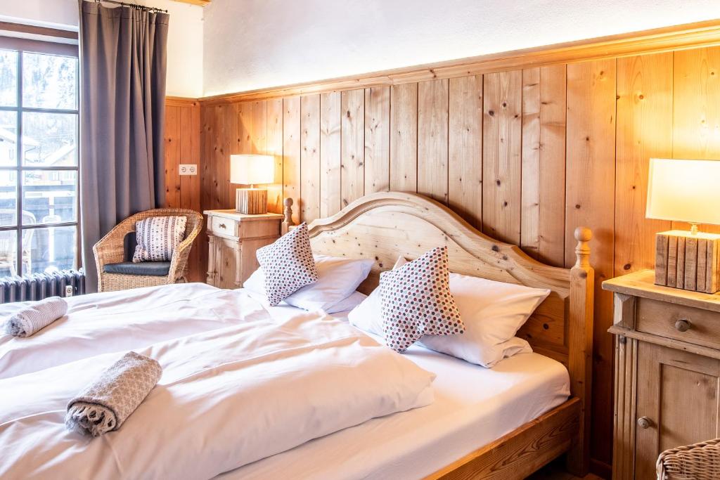 a bedroom with a large bed with a wooden wall at Fischer Apartments in Oberammergau