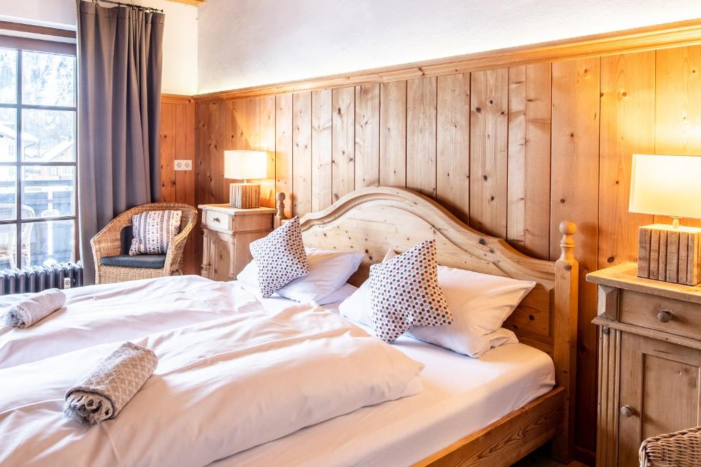 ein Schlafzimmer mit einem großen Bett und einer Holzwand in der Unterkunft Fischer Apartments in Oberammergau