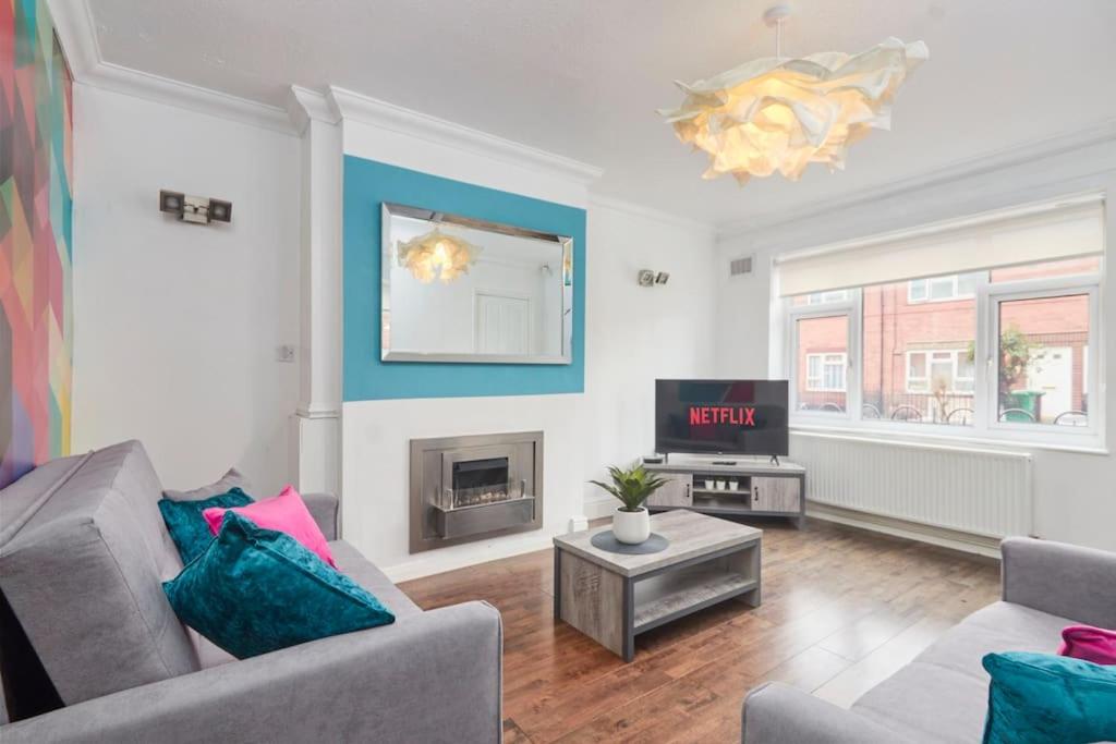 a living room with a couch and a tv at Central Nottingham house in Nottingham