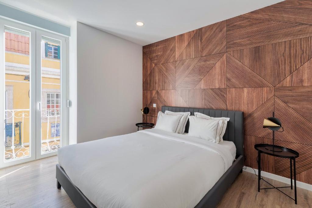 1 dormitorio con 1 cama grande y pared de madera en Golden Setubal, en Setúbal