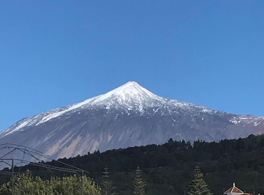 una montaña cubierta de nieve en la cima de una colina en CASA MARA Casa Rural con terraza, barbacoa y vistas al Teide en Tanque