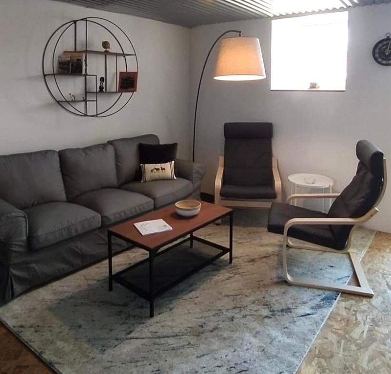 sala de estar con sofá, mesa y sillas en L’Audacieuse, maison atypique, en Aubusson