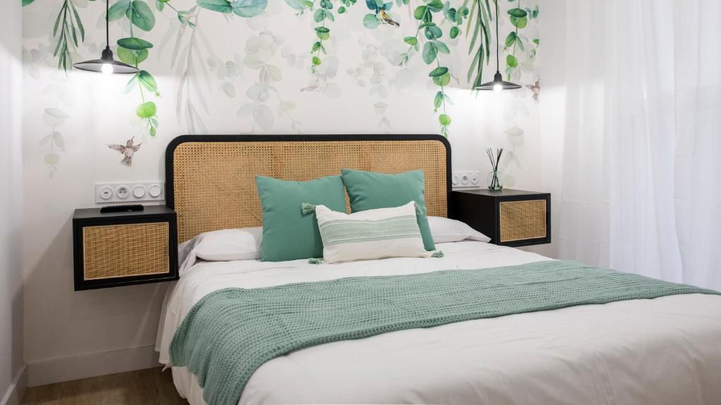 1 dormitorio con 1 cama con almohadas verdes y blancas en Precioso apartamento en Jaén a 70 m de la Catedral en Jaén