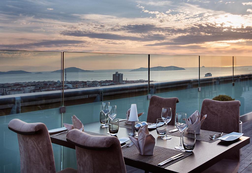 a restaurant with a table and chairs on a balcony at Dedeman Bostanci Istanbul Hotel & Convention Center in Istanbul