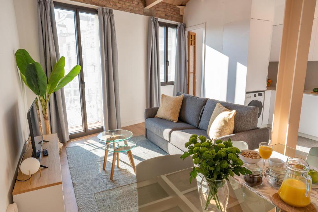 - un salon avec un canapé et une table dans l'établissement Feelathome Stadium Apartments, à L'Hospitalet de Llobregat