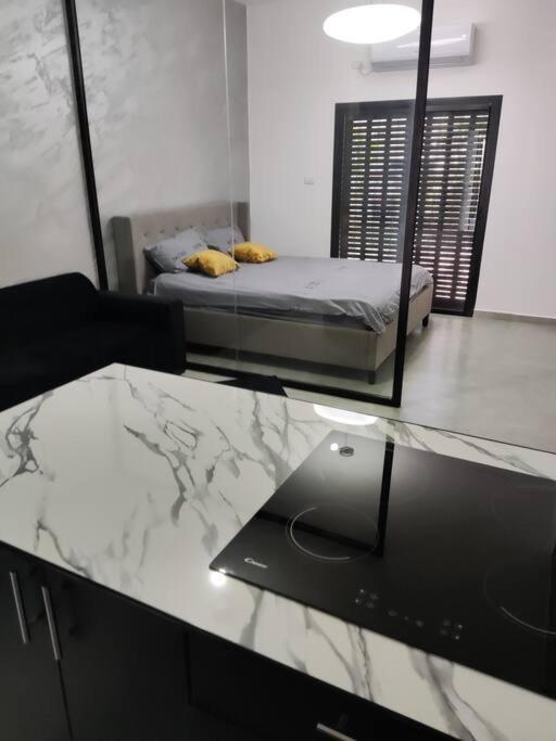 Qiryat Motzkin的住宿－סוויט דרים בגושן，卧室的倒影,卧室配有一张床和一张玻璃桌