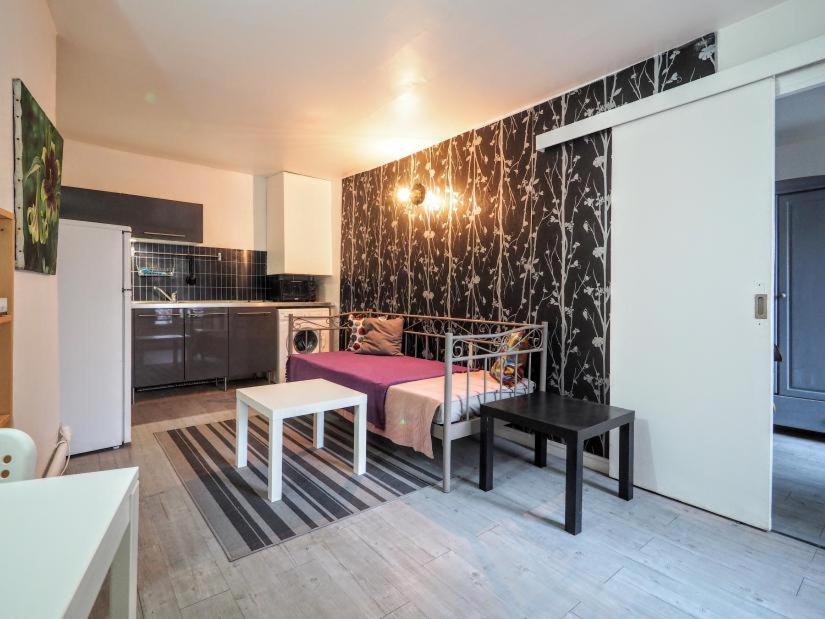 ein Schlafzimmer mit einem Bett und einer schwarz-weißen Wand in der Unterkunft Appartement JARDINS DU LOUVRE in Paris