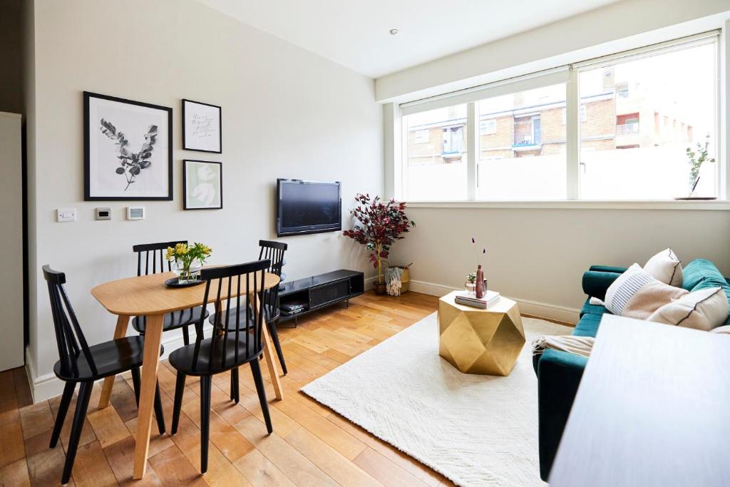 a living room with a table and a couch at The Waltham Forest Escape - Adorable 2BDR Flat in London