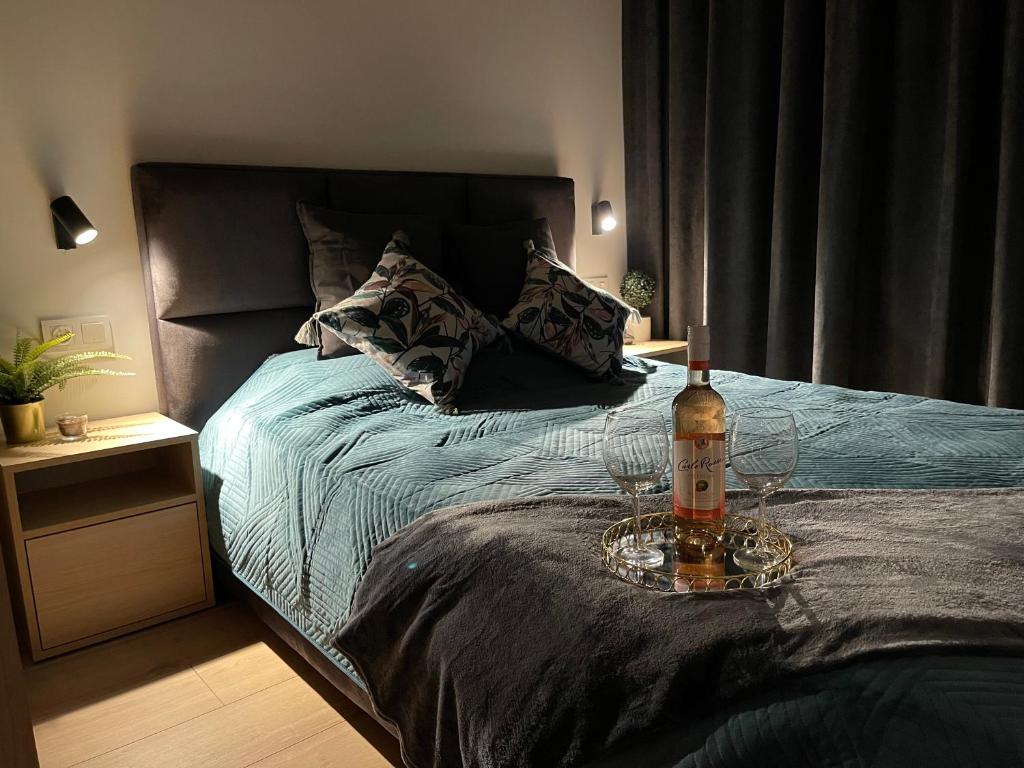 - un lit avec une bouteille et deux verres dans l'établissement Golden Garden Apartment Tuwima Street, à Łódź