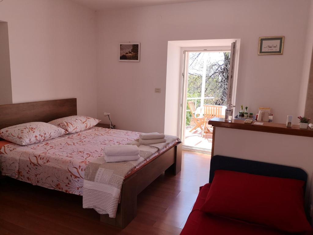 - une petite chambre avec un lit et une fenêtre dans l'établissement Laguna Apartment, à Mlini