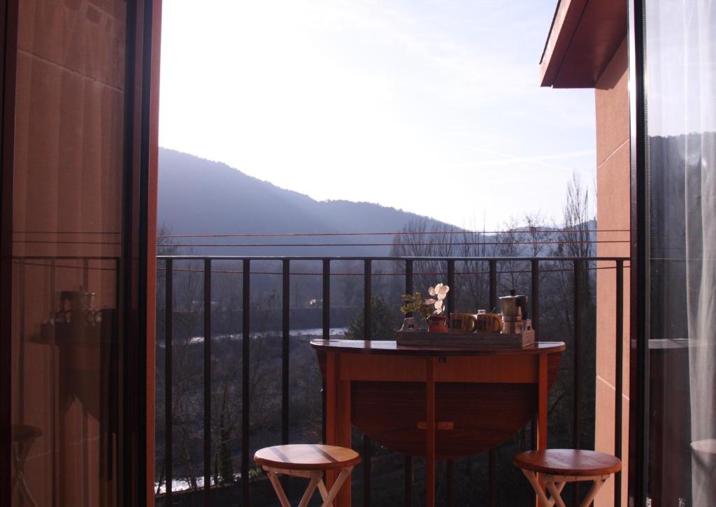 a balcony with a table and two stools at Apartamento Vista al Ara in Aínsa