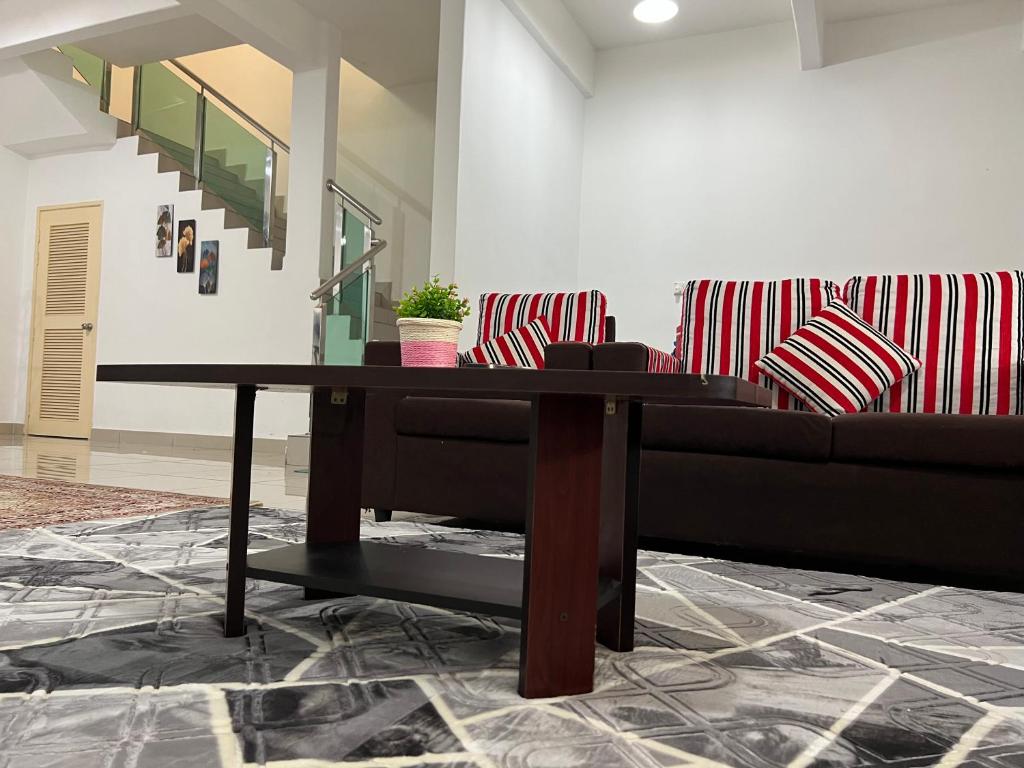 sala de estar con sofá y mesa en De Pontian Homestay, en Pontian Besar