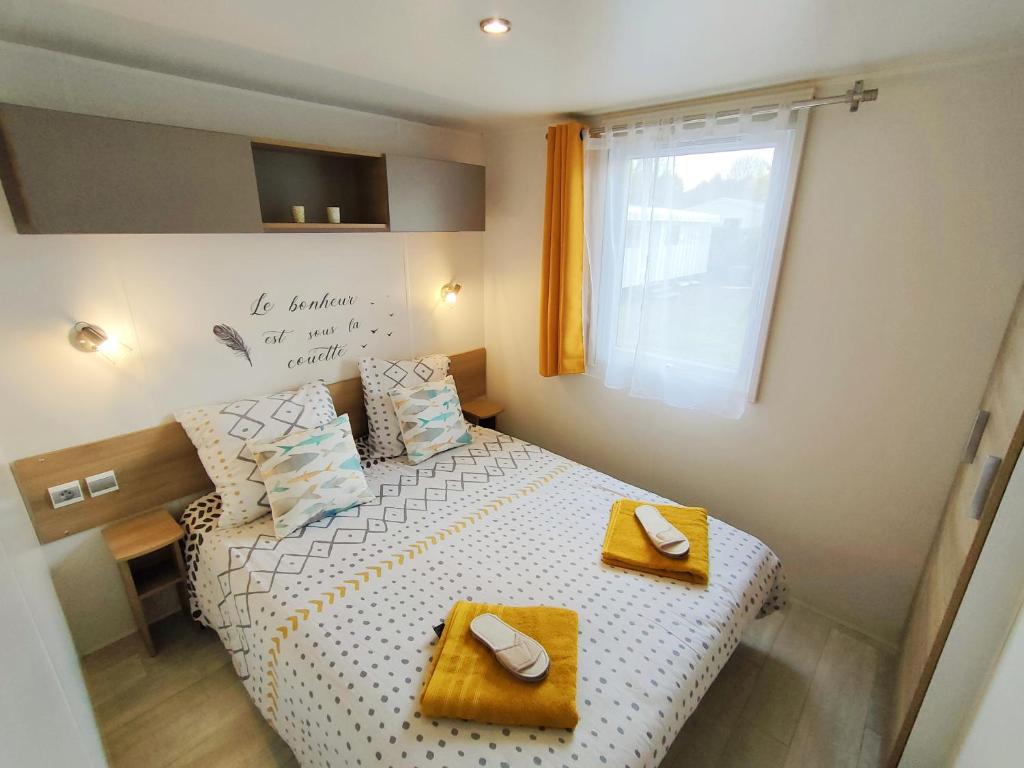 Habitación pequeña con cama y ventana en Vos MEILLEURS Vacances en Mobil Home en Gastes