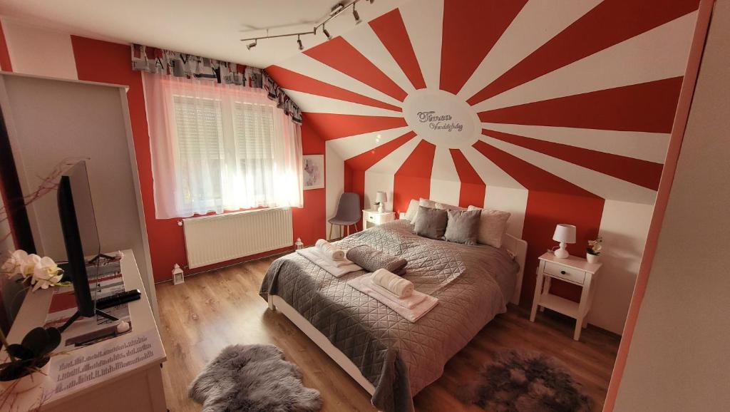 a bedroom with a large red and white striped wall at Tímea Vendégház Zalaszabar in Zalaszabar