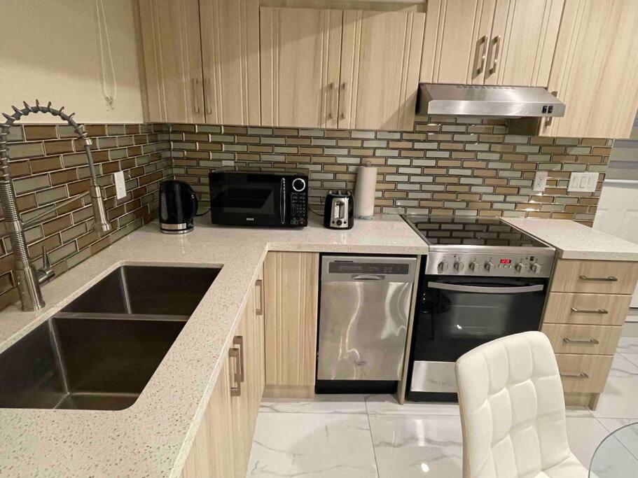 uma cozinha com um fogão, um lavatório e um micro-ondas em Adorable1-Bedroom Basement apartment, free parking em Brampton