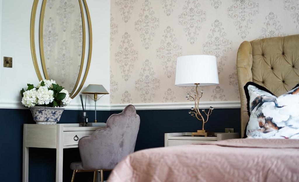 a bedroom with a bed and a chair and a mirror at 40 Winks Hospitality in Durham