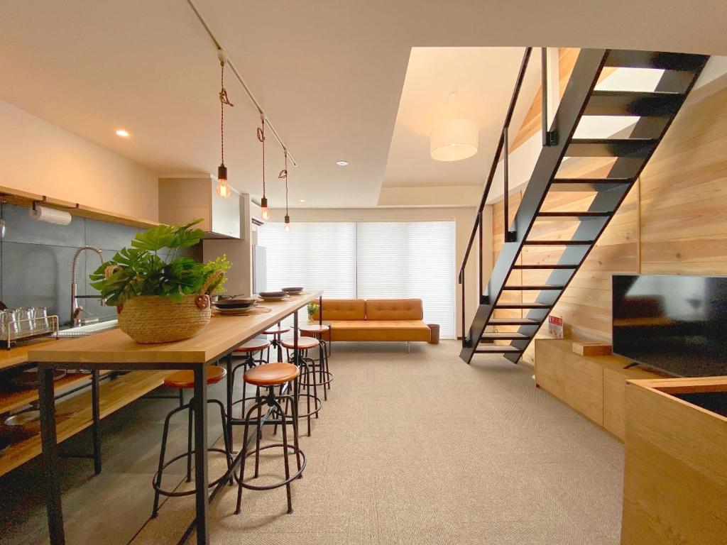 uma cozinha com um bar com bancos e uma escadaria em YS Building 3F - Vacation STAY 31281v em Kakegawa
