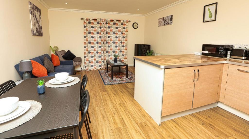 a living room with a kitchen and a dining room at SureSpring Apartment in Slades Green