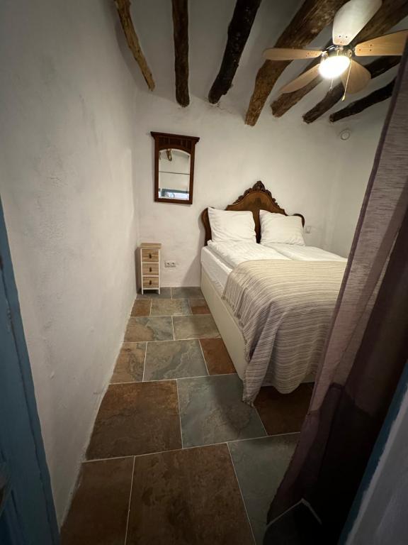 um quarto com uma cama e piso em azulejo em Casa Fabian em Polopos