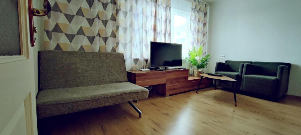 - un salon avec deux chaises et une télévision dans l'établissement Akropole Apartment in Riga, à Riga