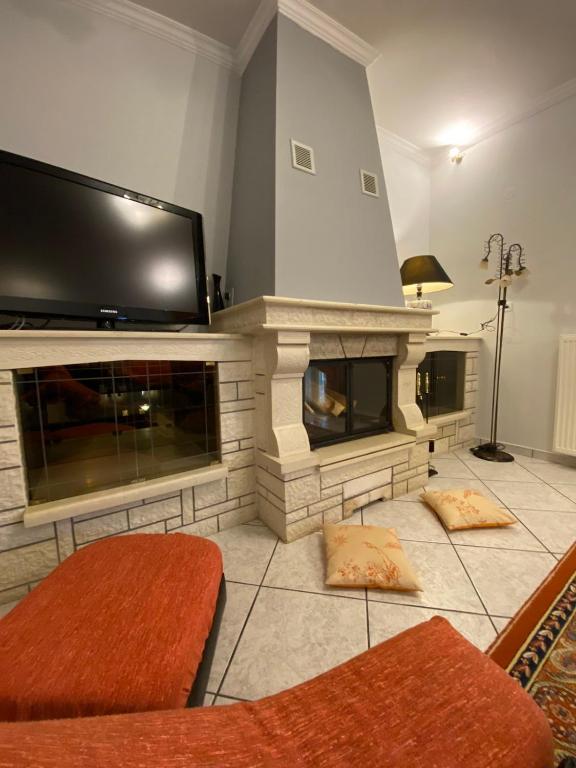 a living room with a fireplace with a flat screen tv at Sitara's House in Karpenisi