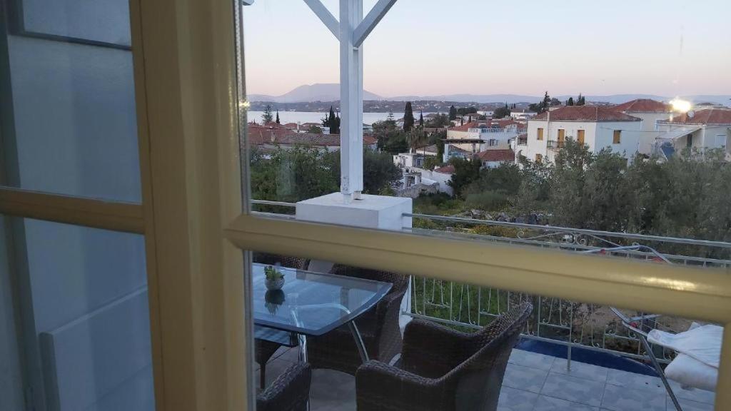 a window with a table and a view of a city at KAS RESIDENCE renovated 2022 in Spetses