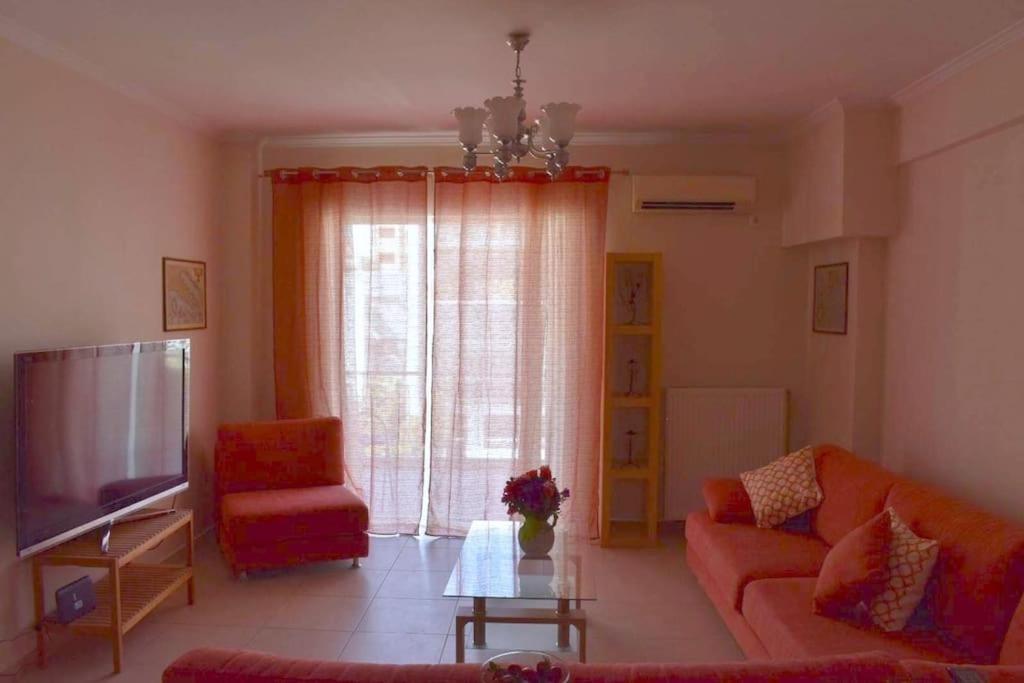 a living room with a couch and a television at Stavros Niarhos apartment in Athens