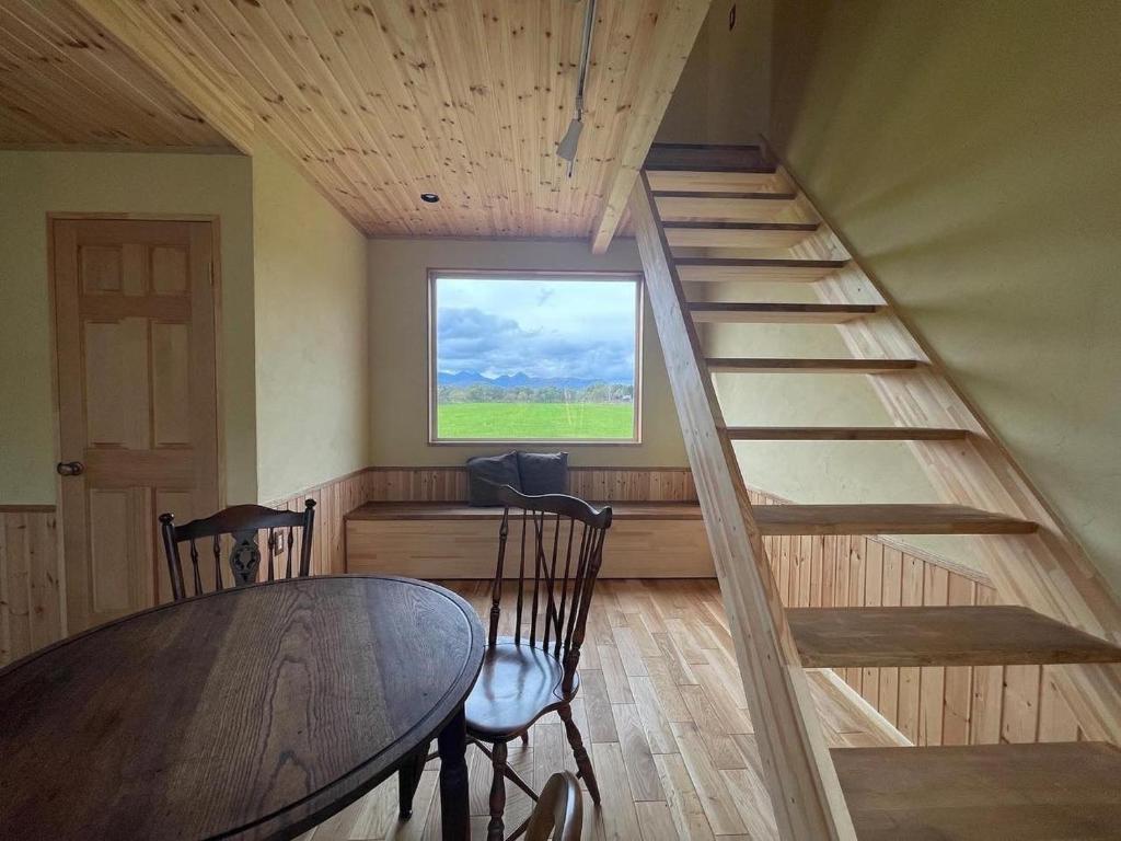 eine Treppe in einem Zimmer mit einem Tisch und einem Fenster in der Unterkunft Forest-House-Ranapirica - Vacation STAY 52421v 