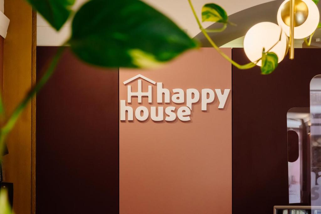 a sign for a happy house with a plant at Happy House in Faro