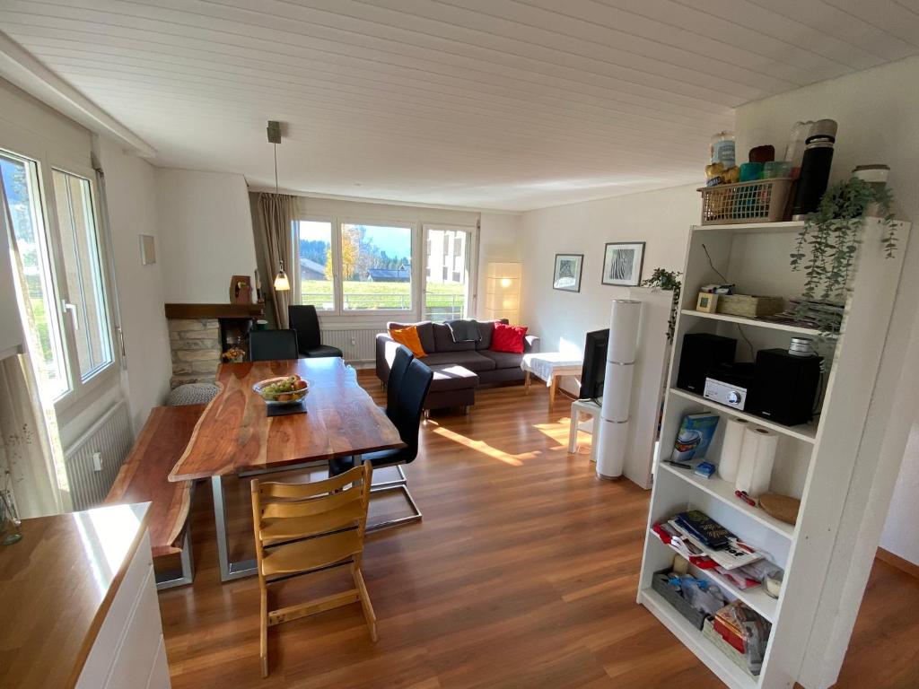 kuchnia i salon ze stołem i krzesłami w obiekcie Apartment Arvenbüel-Flüügespitz w mieście Amden